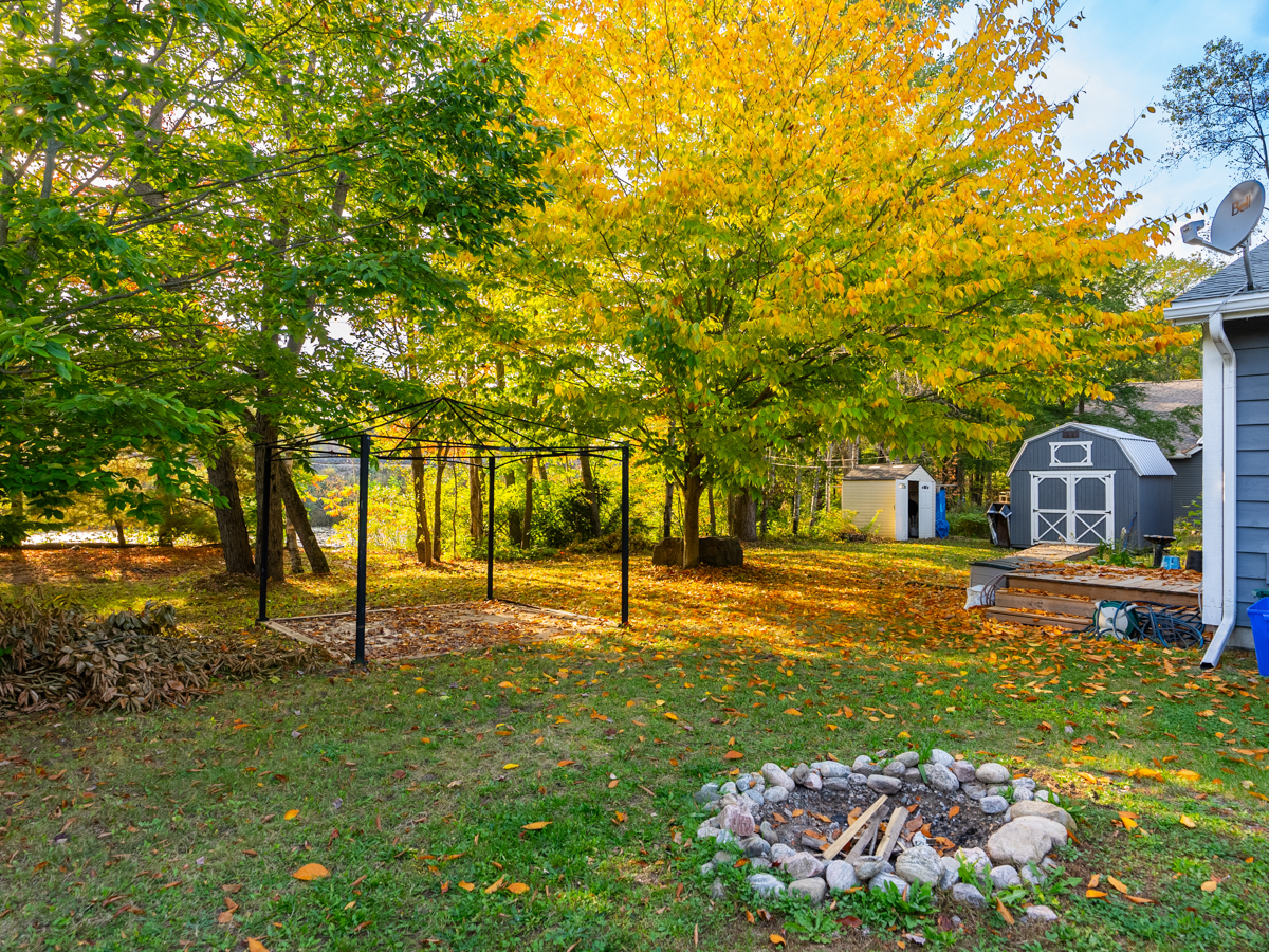 Backyard area with a small fire pit and a shed.