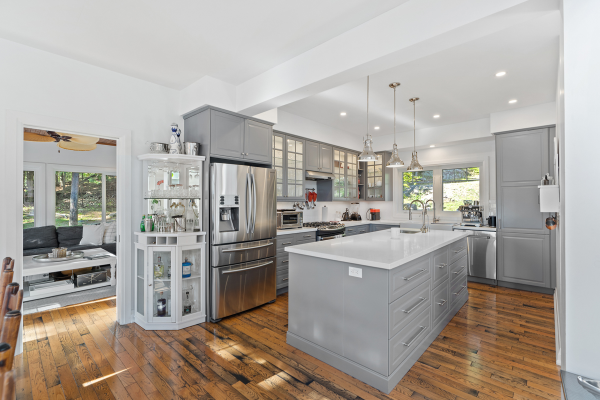 A big, modern kitchen with an island, modern appliances, and light grey cabinets.