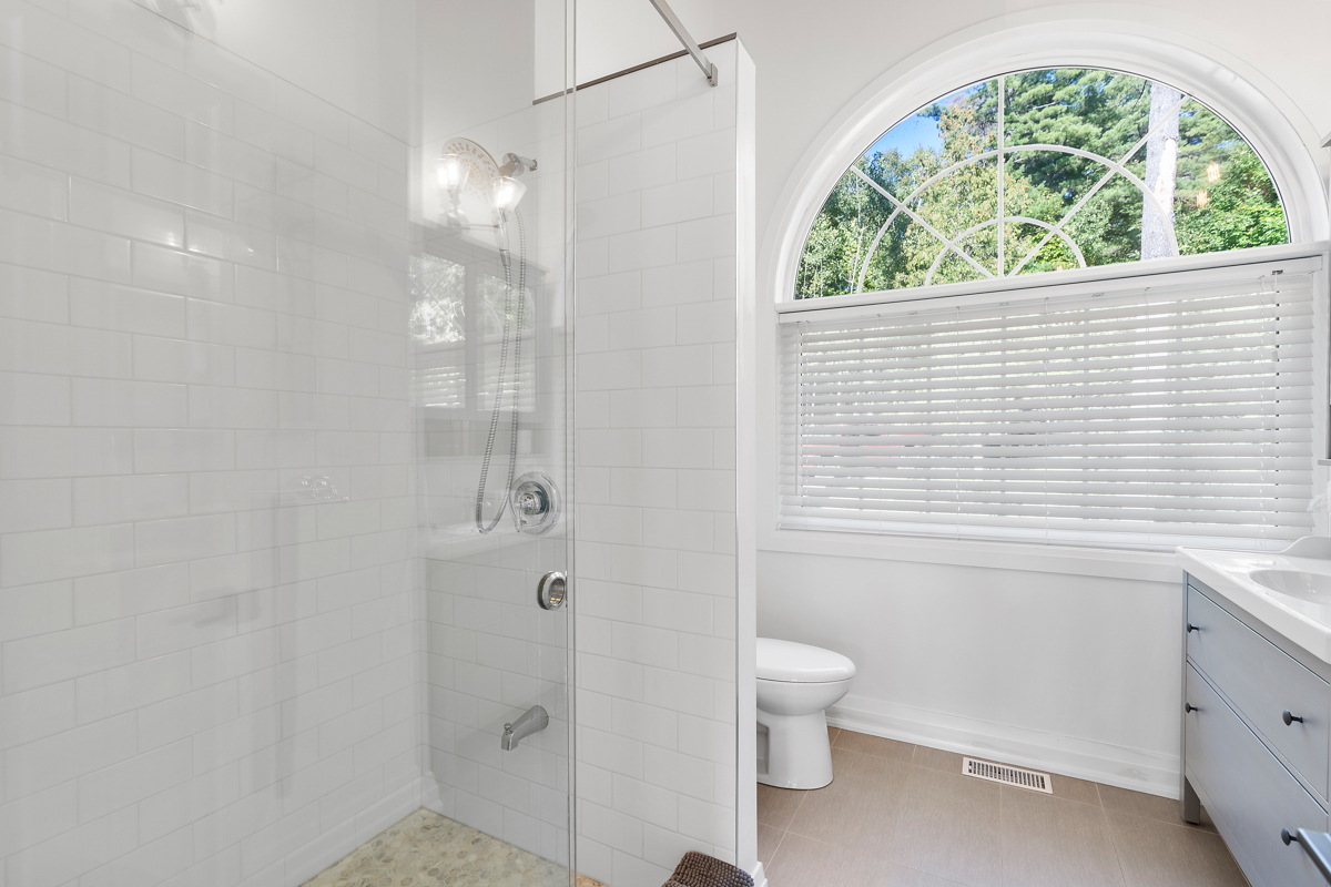 A big bathroom with a toilet and a walk-in shower.