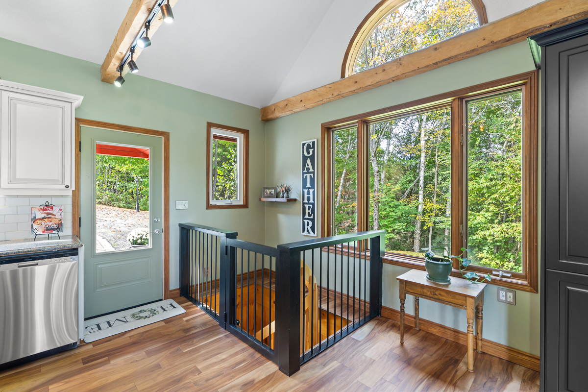 Inside a front door. To the side, a gate blocks off a spiral staircase that leads down to a lower level.