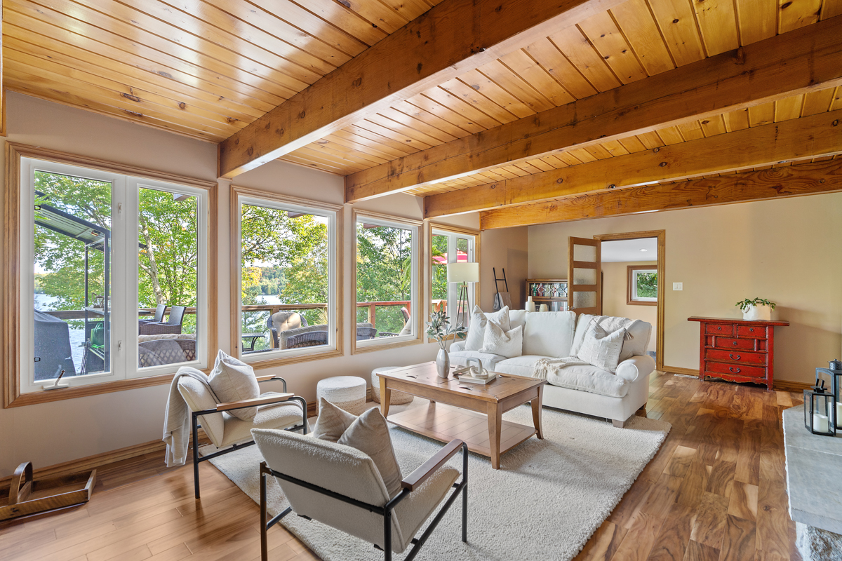 A bright living area with white furniture and lots of windows.
