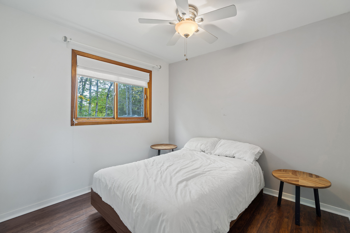 A small bedroom with a bed and a ceiling fan.