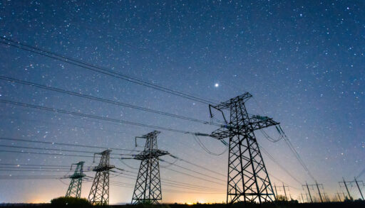 High-voltage power lines on the background of the starry sky
