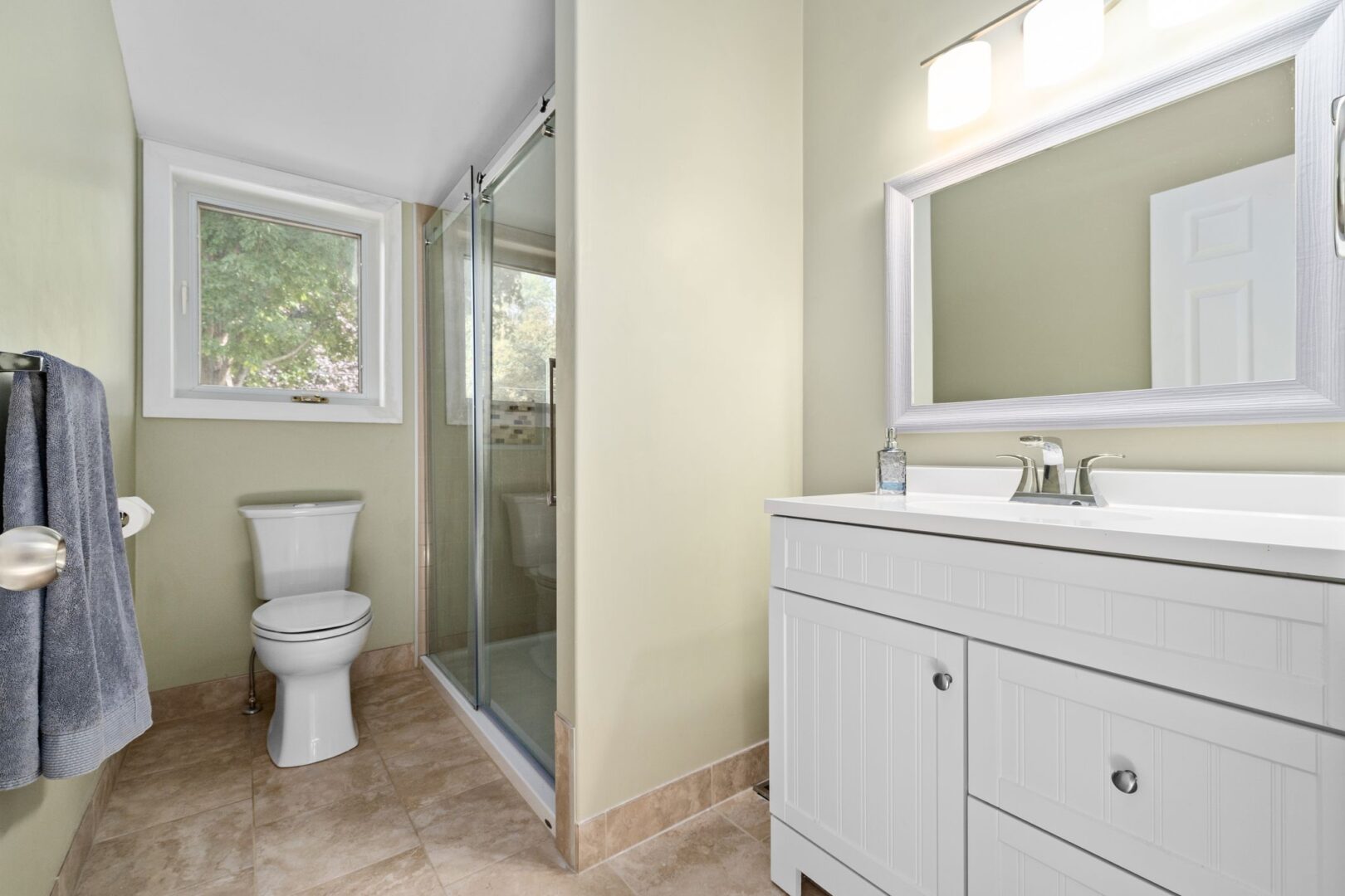 A bathroom with a toilet, a sink, and a walk-in shower.