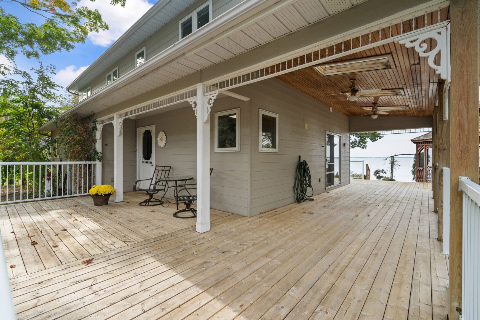 A large porch wraps around a two-story cottage.