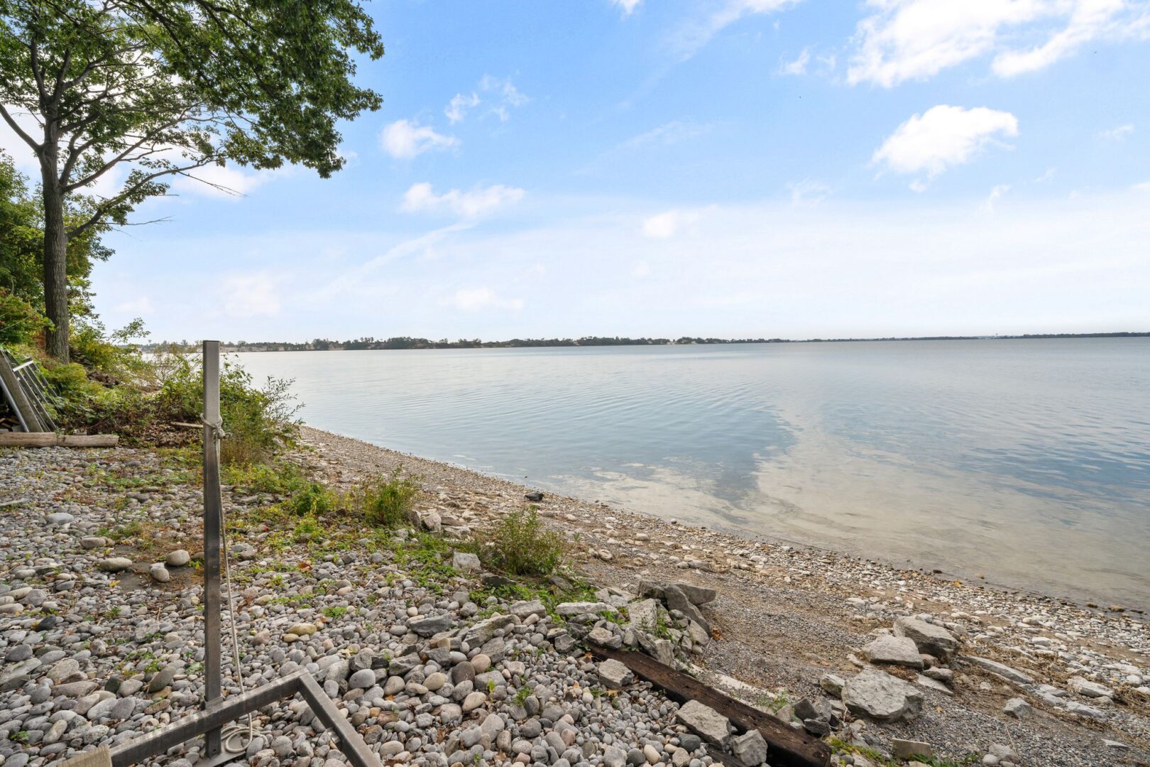 A rocky shoreline looking out over a calm lake.