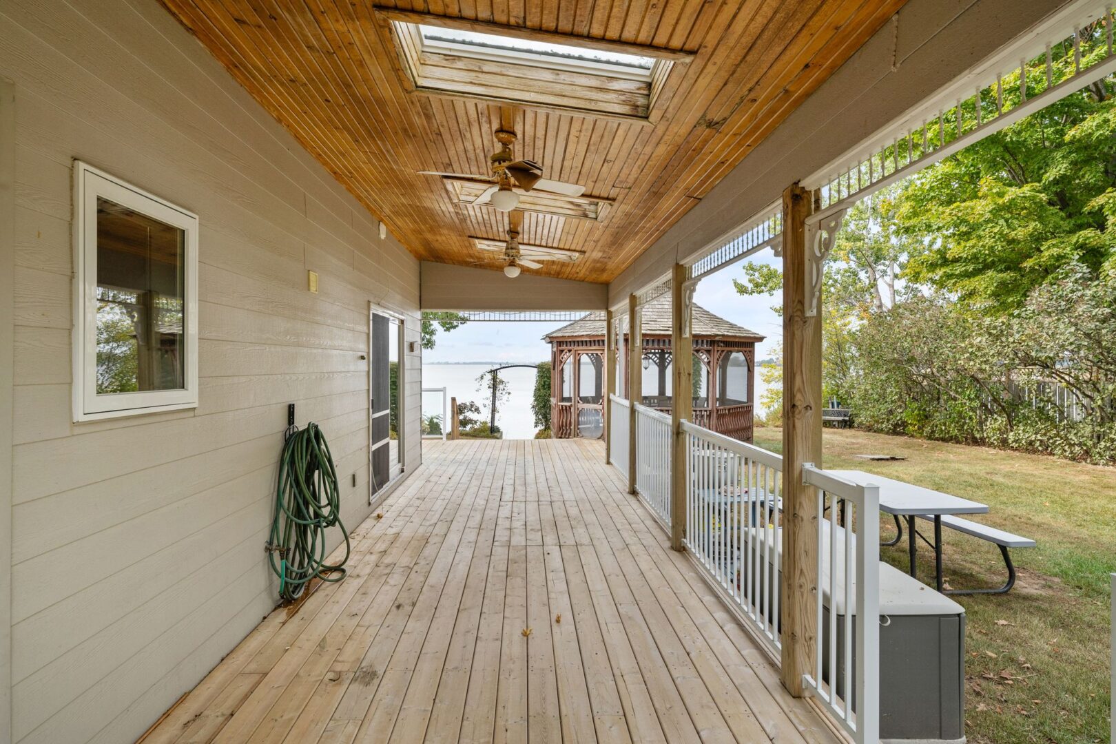 A long, covered porch on the side of a cottage.