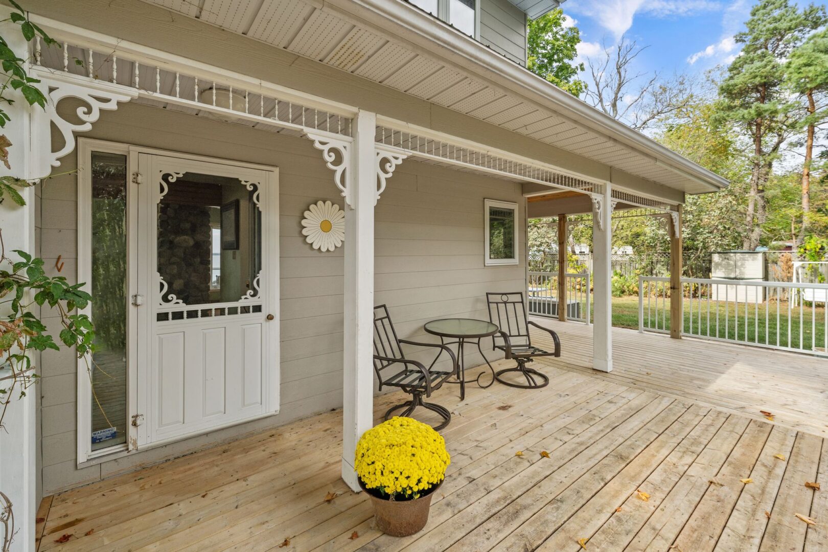 The of a cottage, with a large porch and a white screen door.