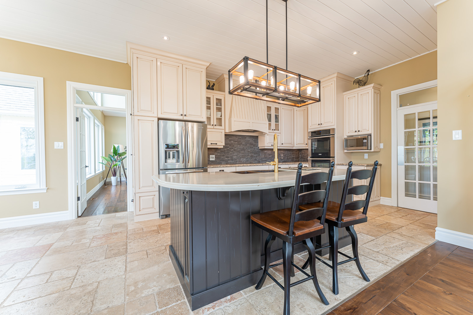 A bright, updated kitchen with tile flooring and a large island.