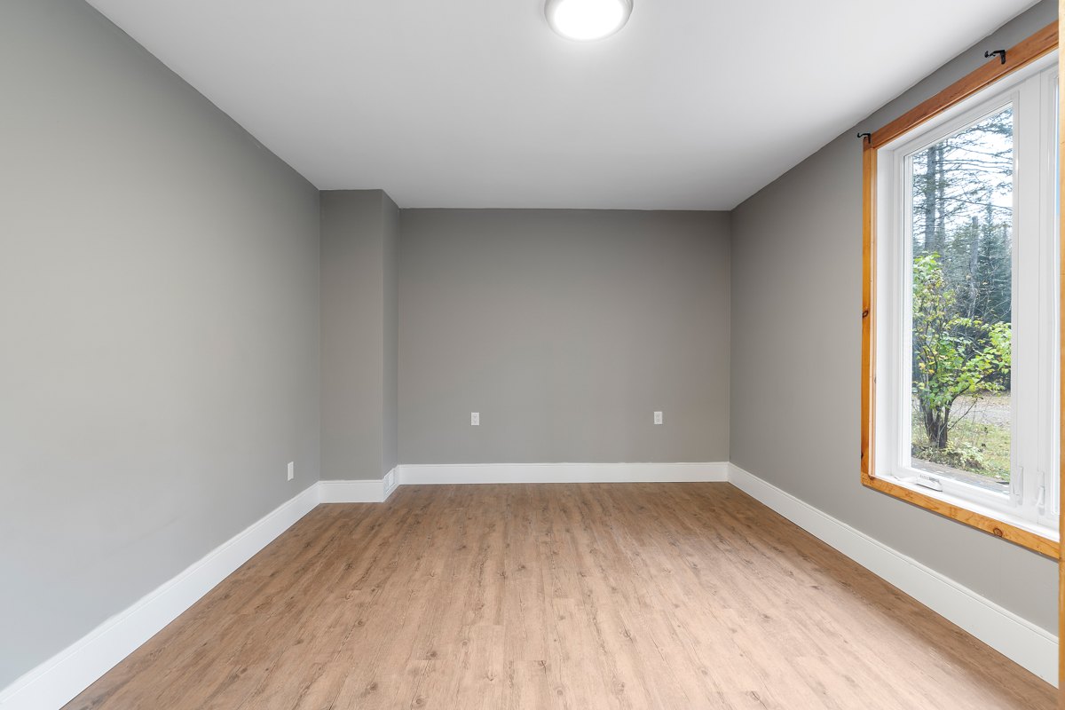 A large, empty bedroom with grey painted walls.