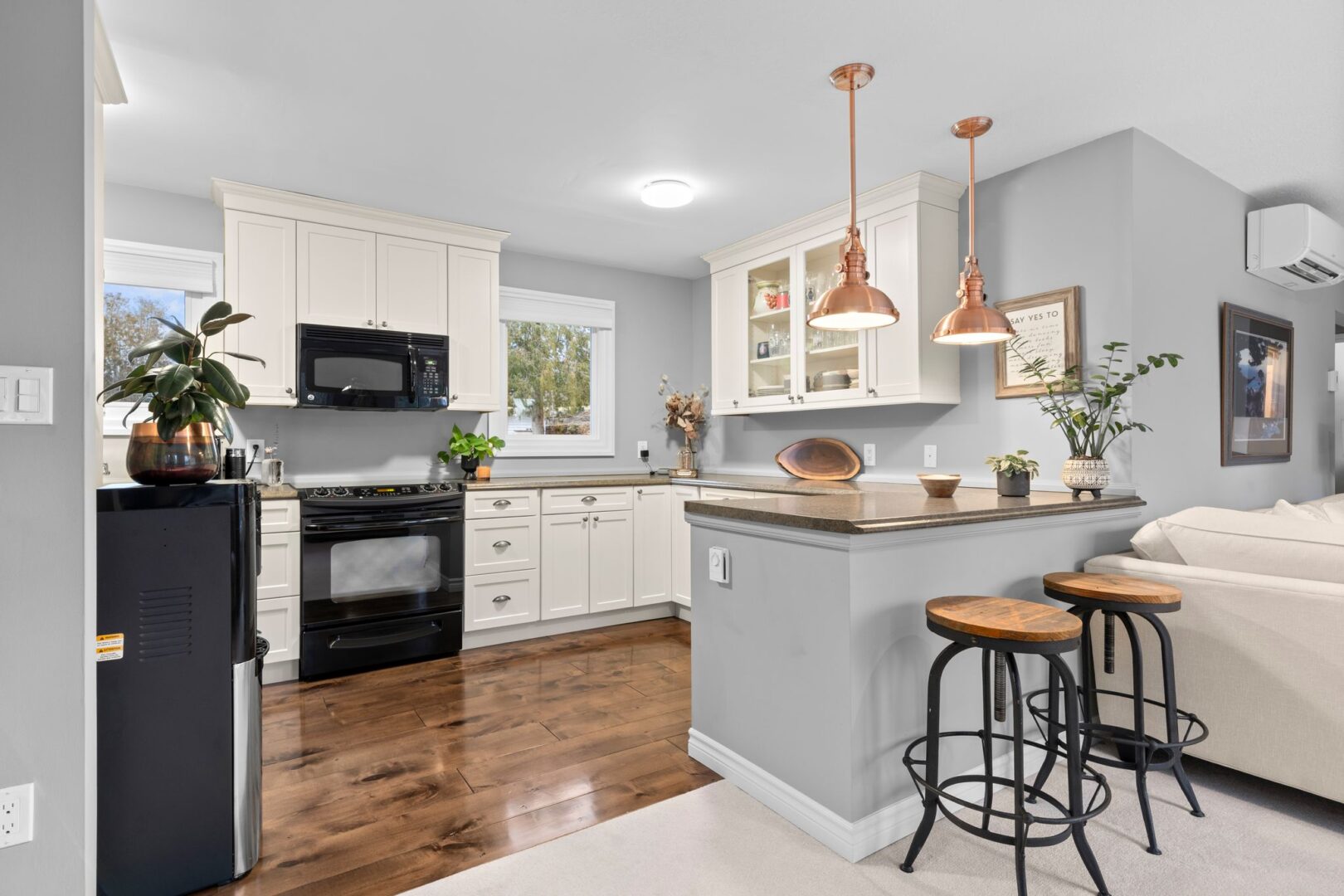 A bright kitchen with white cupboards and a peninsula.