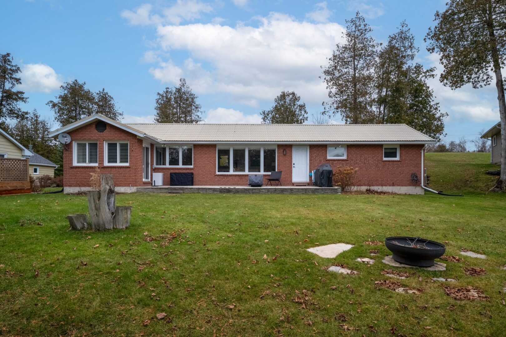 A red-brick bungalow sits on a grassy lot.