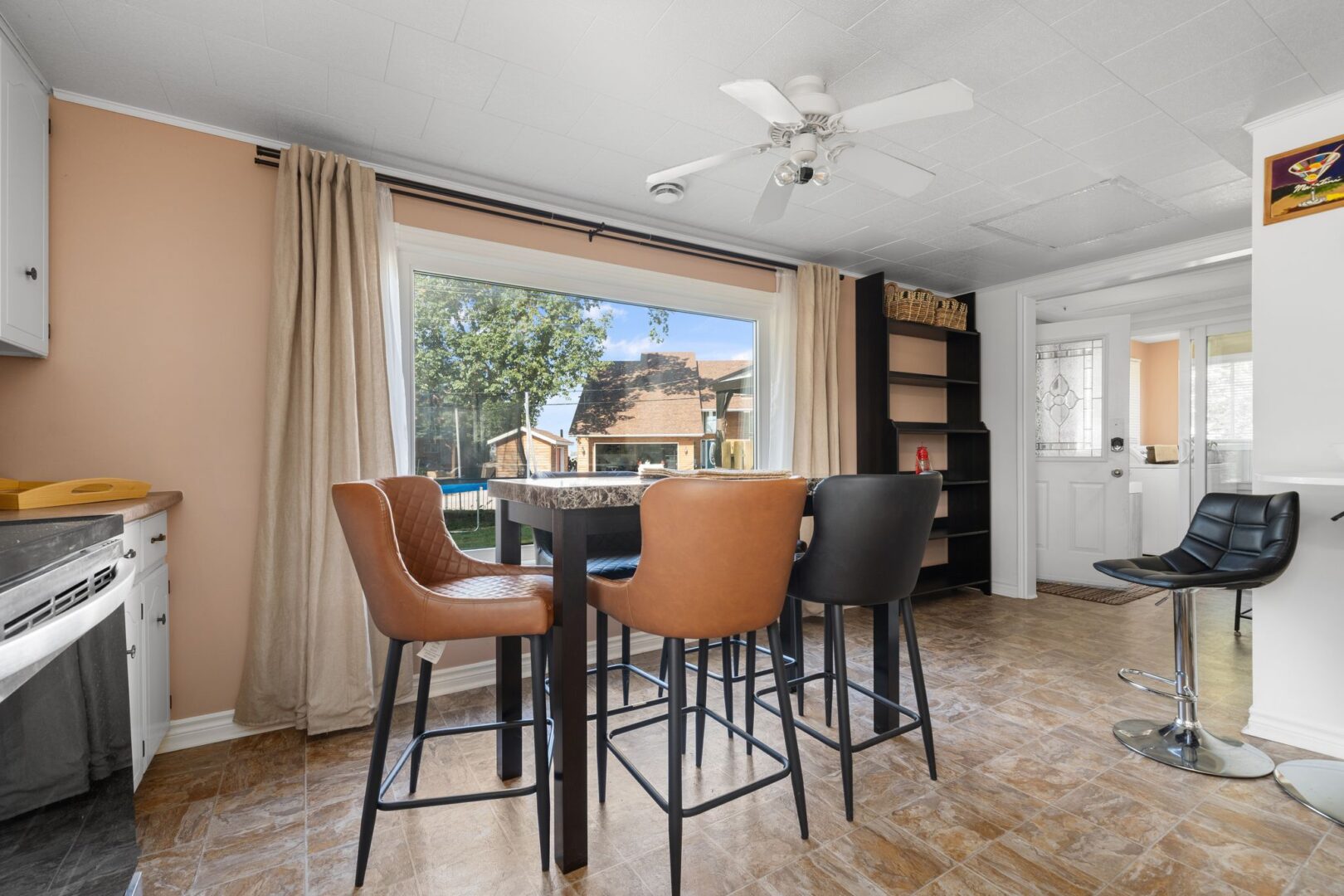 A bright dining space with a table, chairs, and a big window.