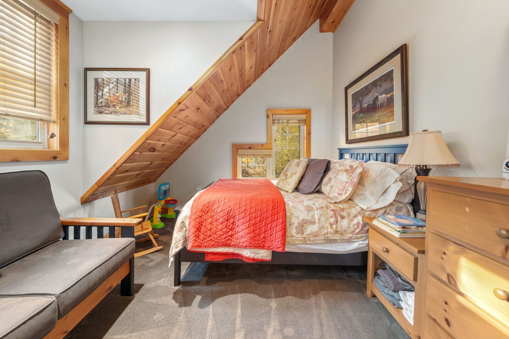 A small but bright bedroom with a medium-sized bed and a sloping ceiling.