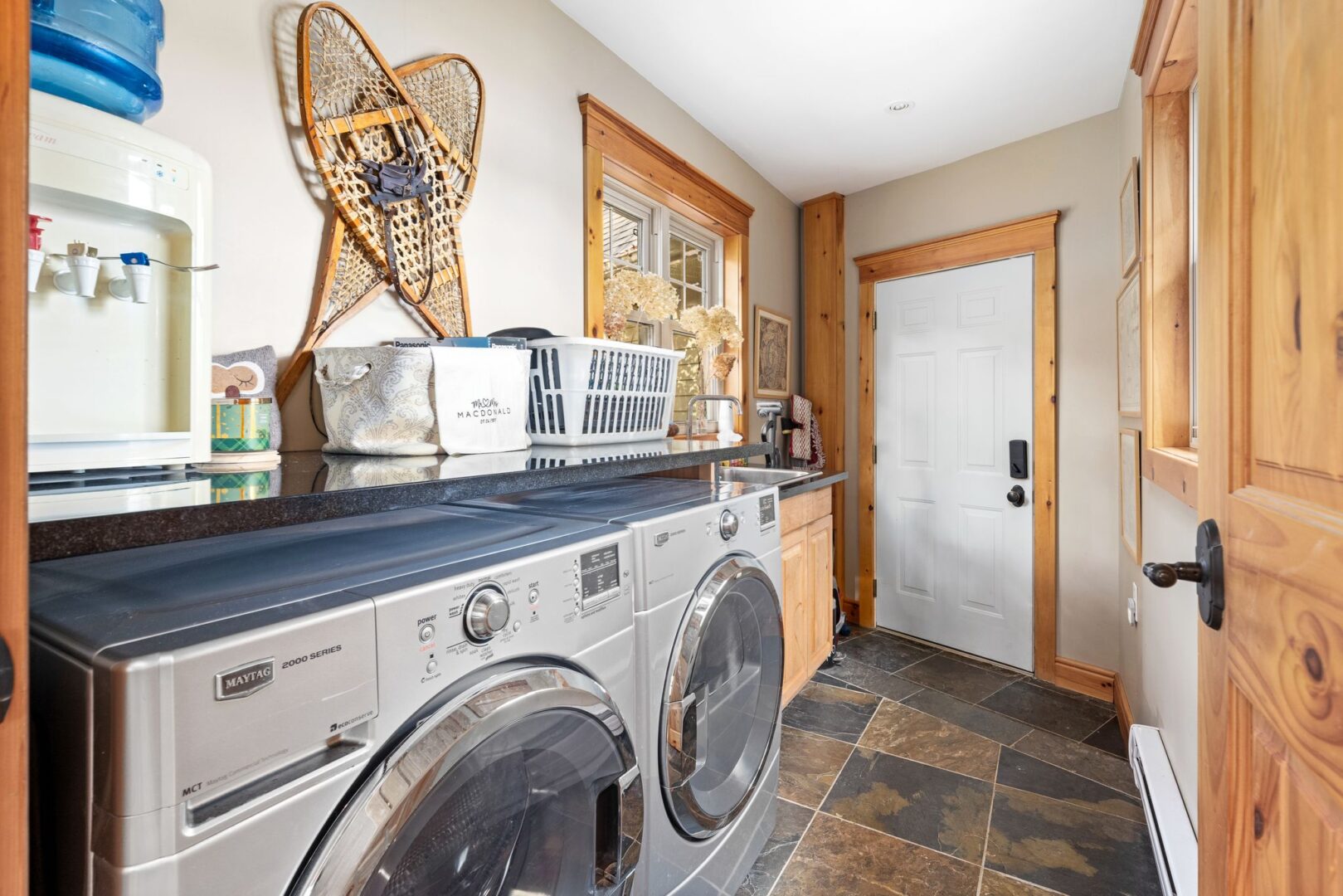 A mudroom area with tile flooring, a washing machine, and a dryer.