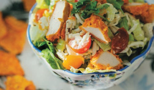 a photo of a salad topped with chicken