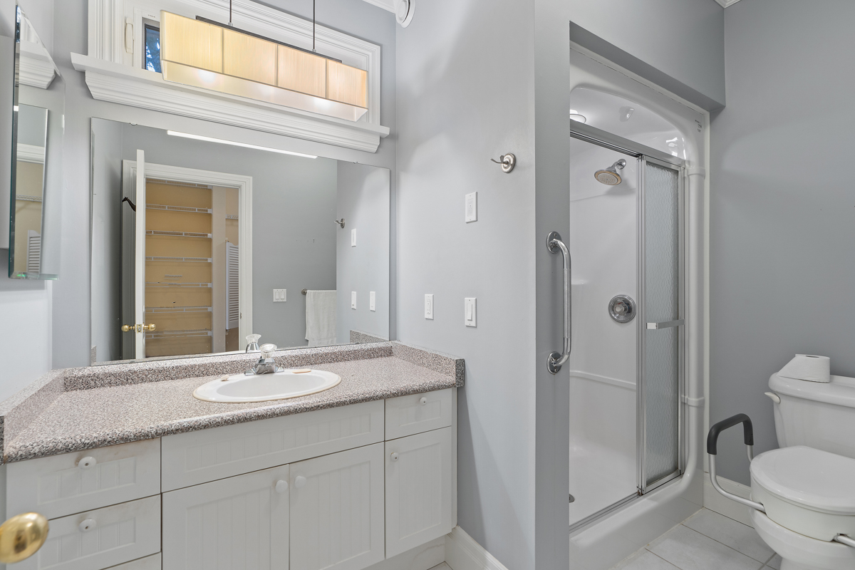 A full bathroom with a toilet, a sink, and a walk-in shower.