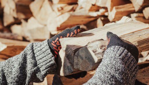 A close-up of male hands stacking firewood