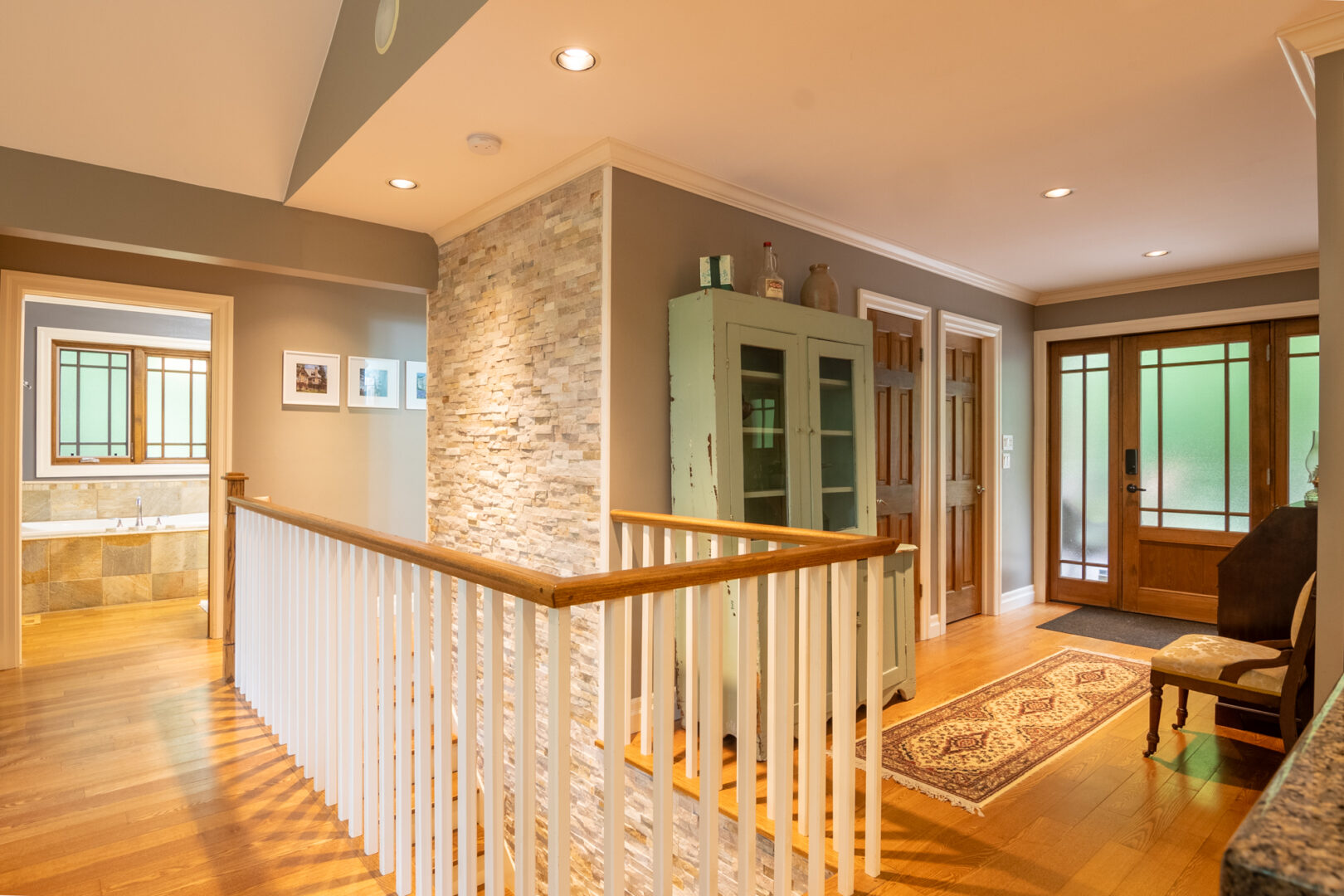 A white railing surrounds a staircase that leads down to a lower level.