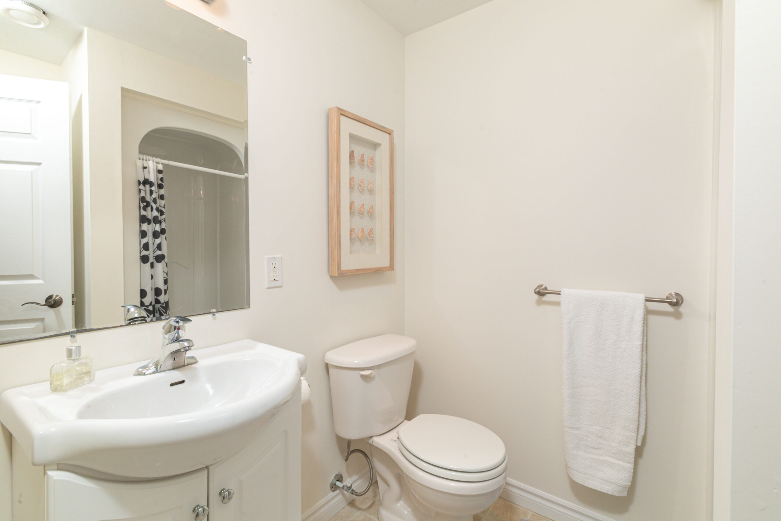 A small bathroom with a toilet, a sink, and a shower.