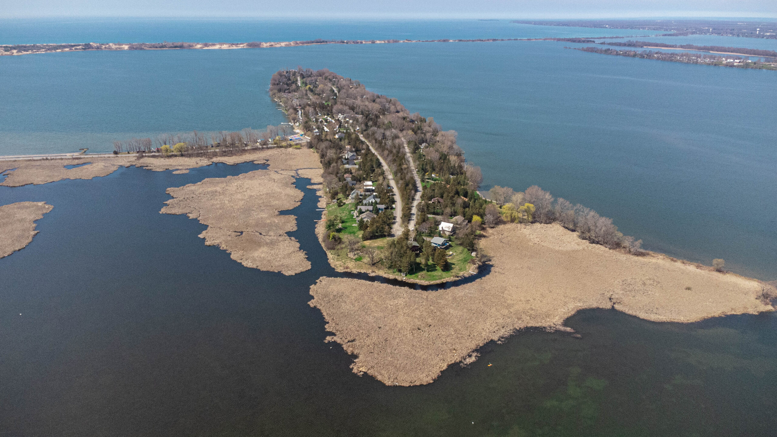 Overhead view of a narrow peninsula of land stretching into a lake.