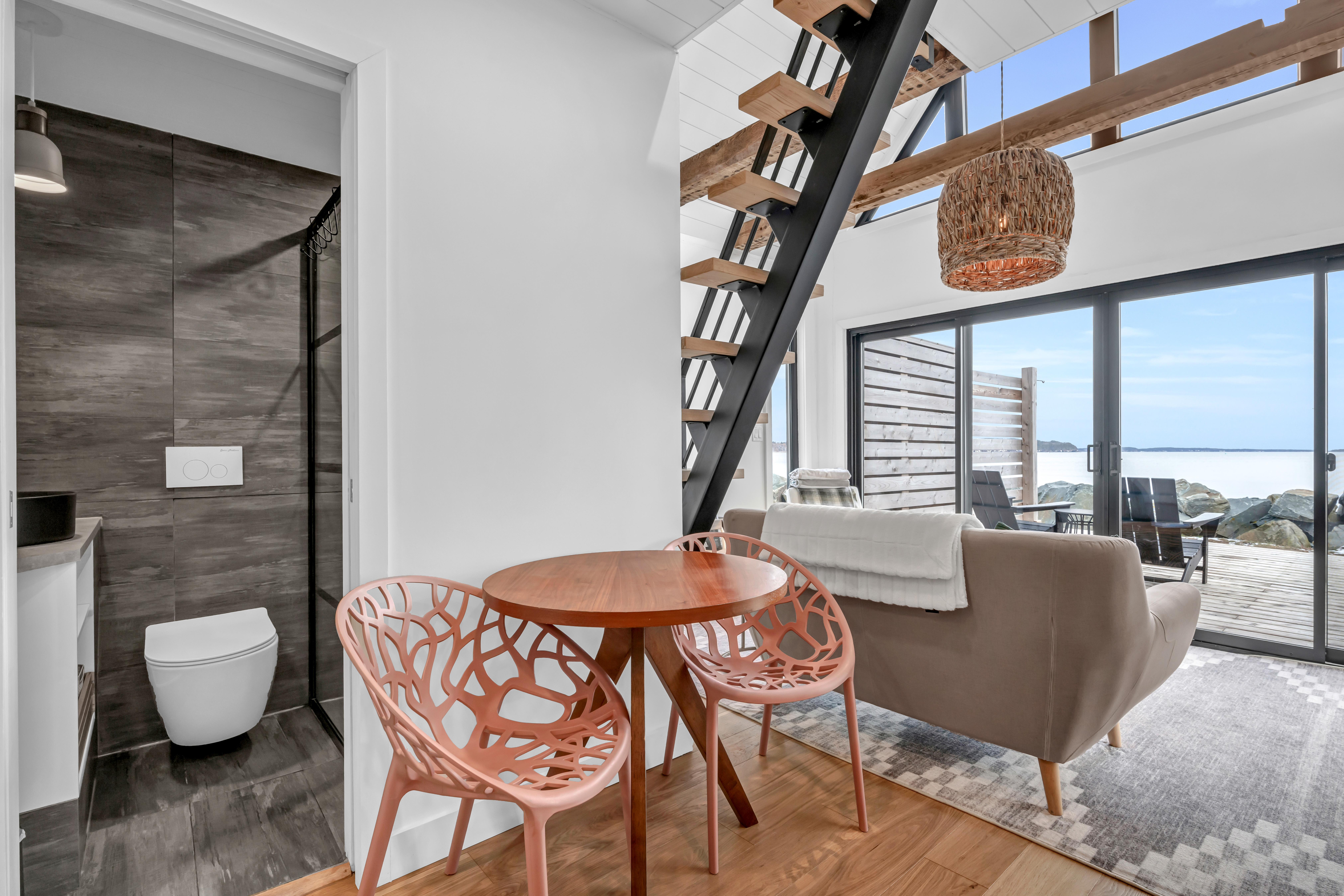 A small table and chairs between a kitchen and living area in an open-concept space.