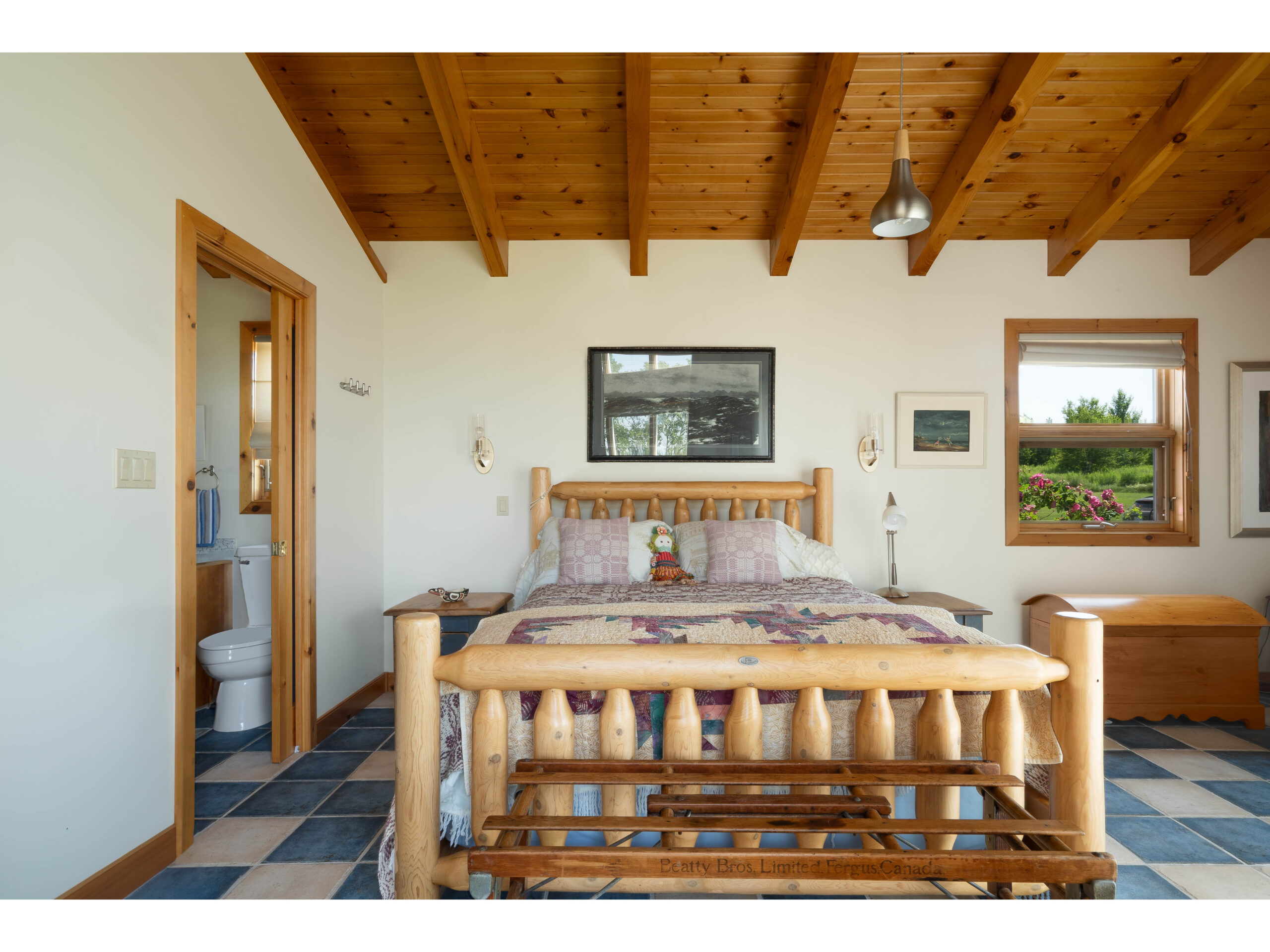 A cozy bedroom with a big bed and wood accents.
