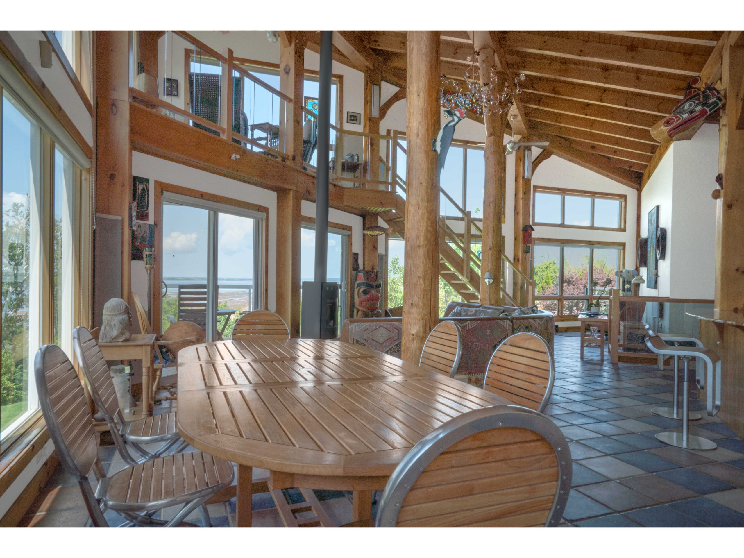 A round dining table surrounded by chairs, in a bright open-concept living and dining area.