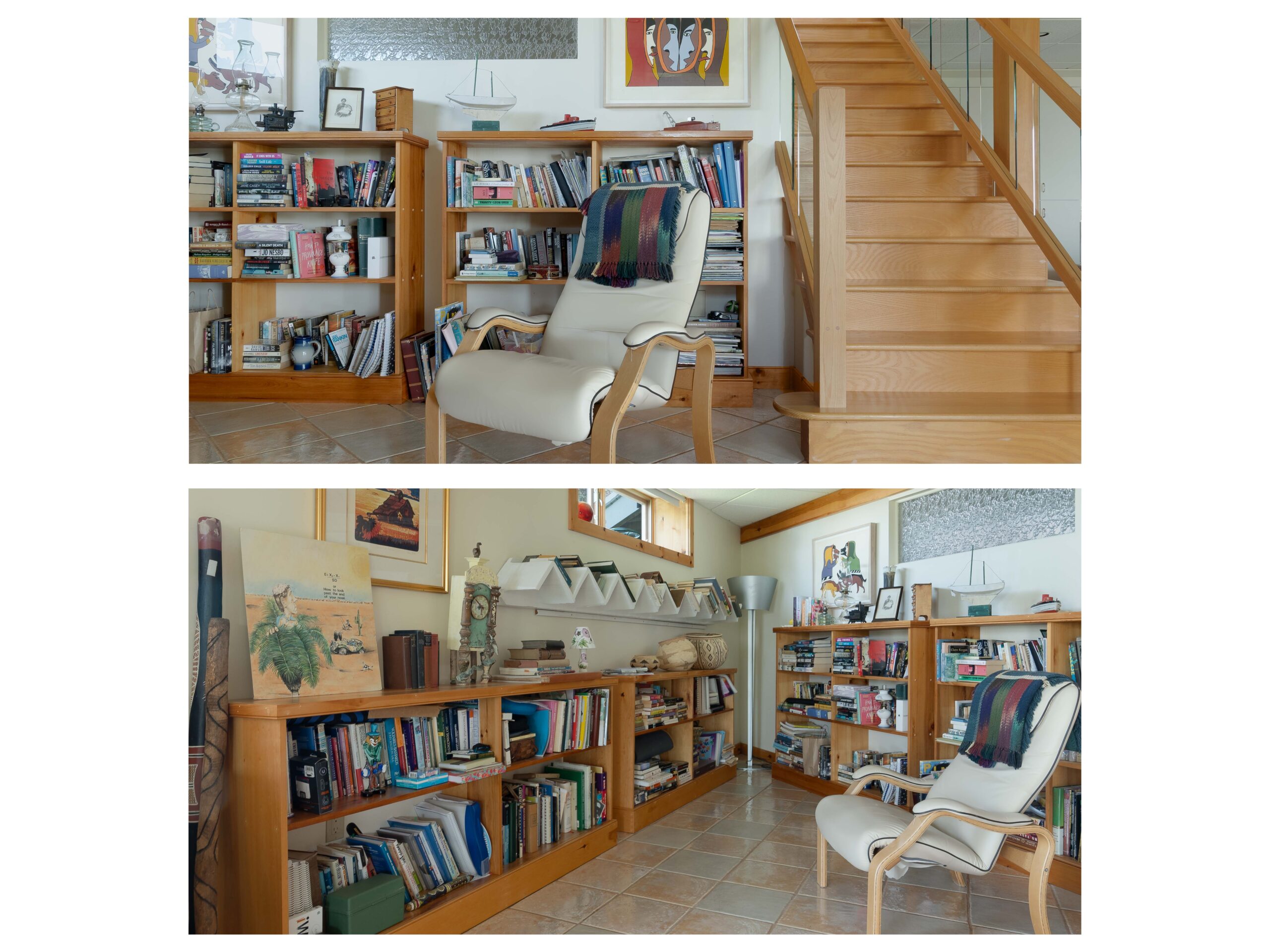 A small library space at the bottom of a wooden staircase. Low shelves line the walls, filled with books, and a white chair sits in the middle of the room.