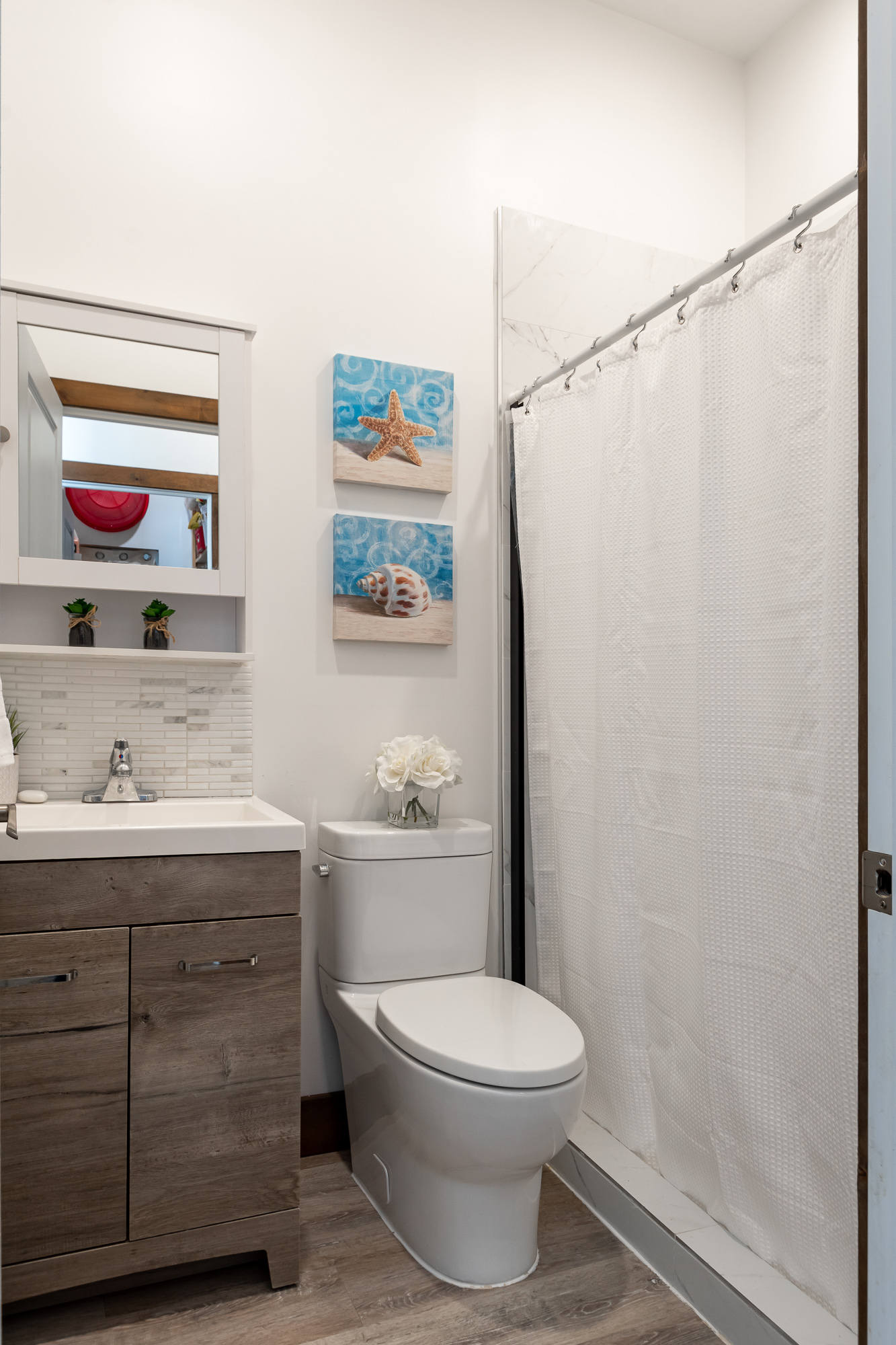 A bathroom with a sink, toilet and shower