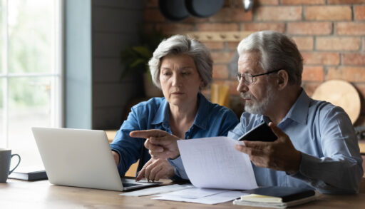 A senior couple doing paperwork at a table