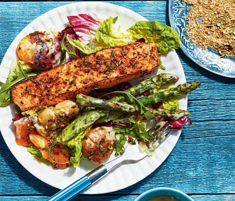 A white plate loaded with salmon and bright vegetables