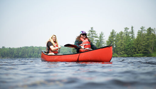Two canoeists paddle on Bigwind Lake