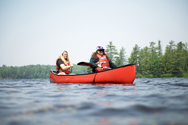 Two canoeists paddle on Bigwind Lake