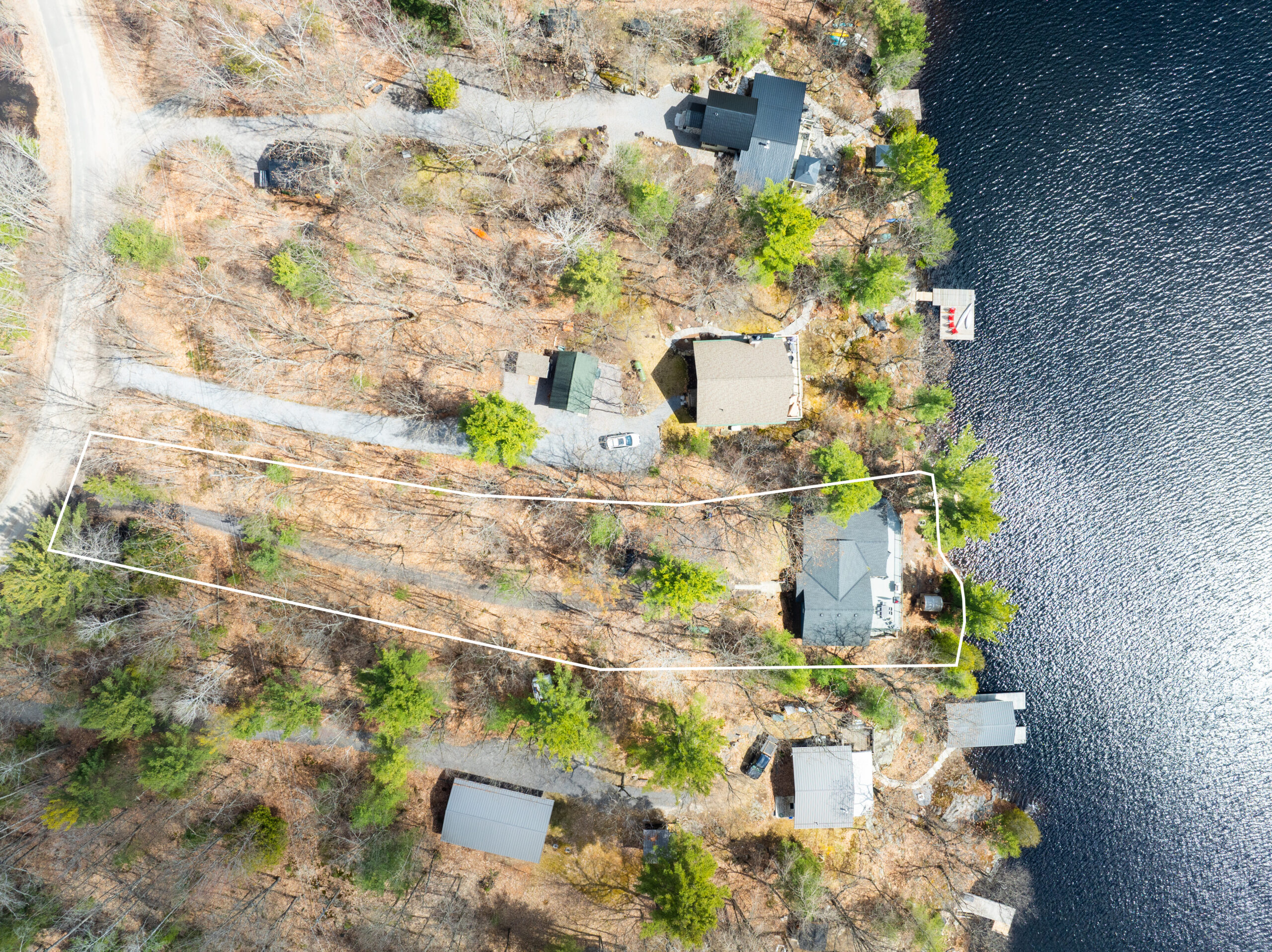 Aerial view of the property. A long road leads to the cottage that overlooks the lake