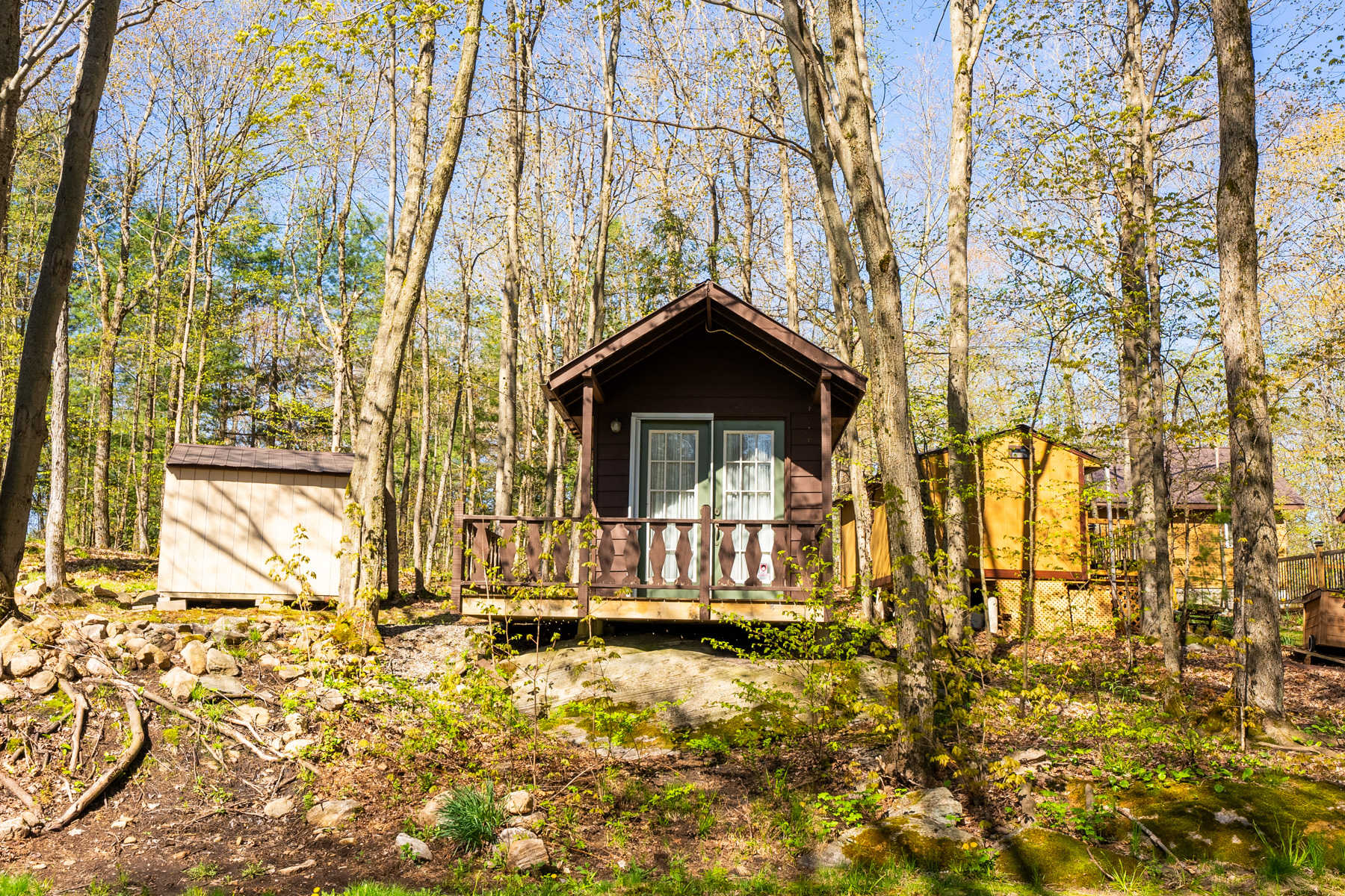 A small wooden cabin with a little deck and French doors.