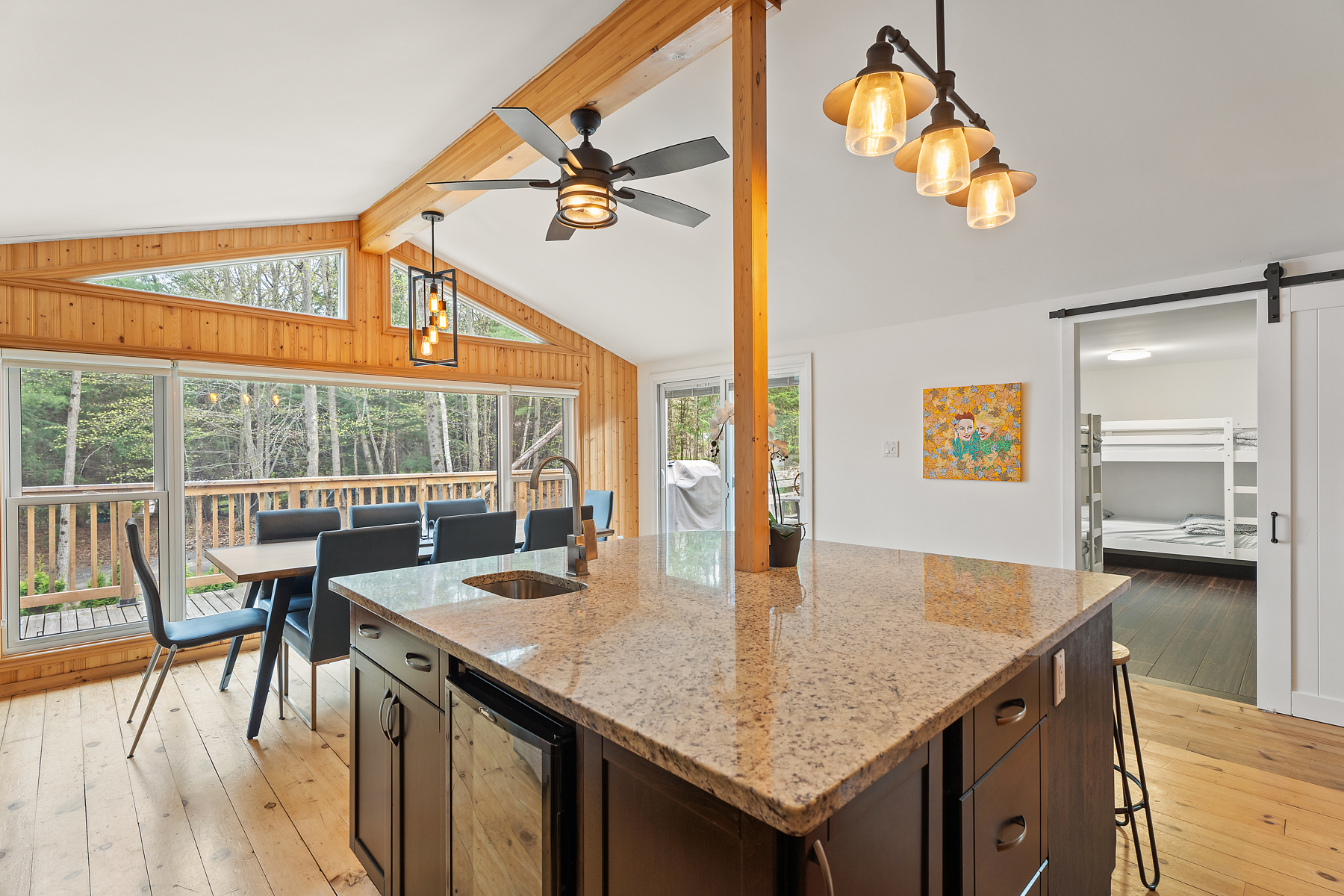 A large kitchen island with a granite countertop, a sink, lots of drawers and cupboards, and a dishwasher.