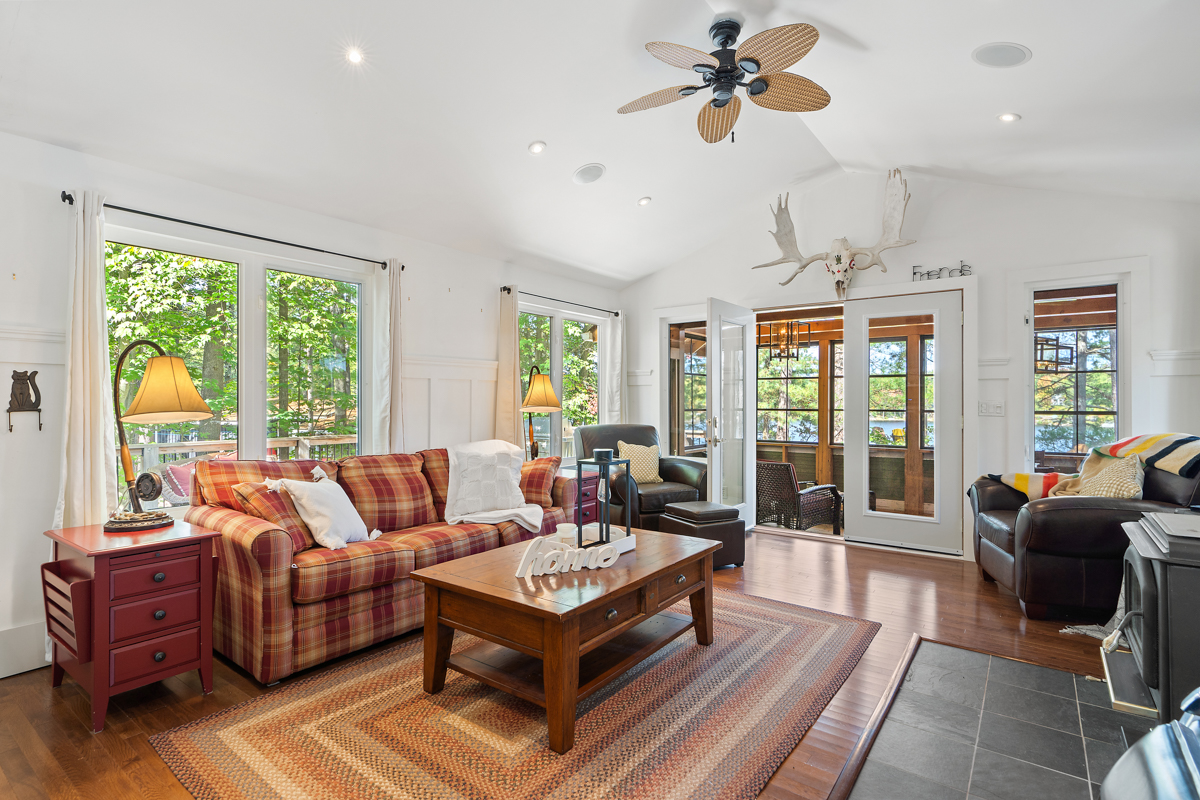 Main living area has a red and yellow couch, brown coffee table that face the wood stove