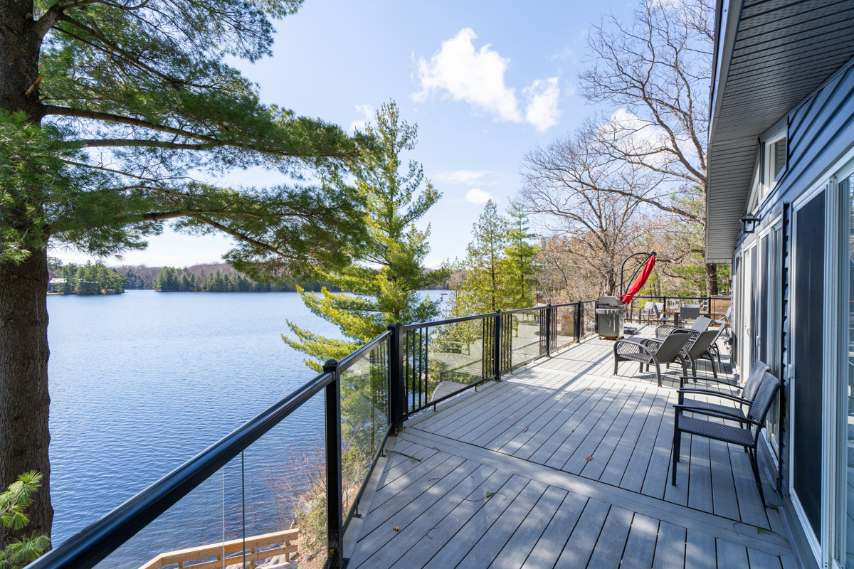 The deck with glass rails leads to a seating area