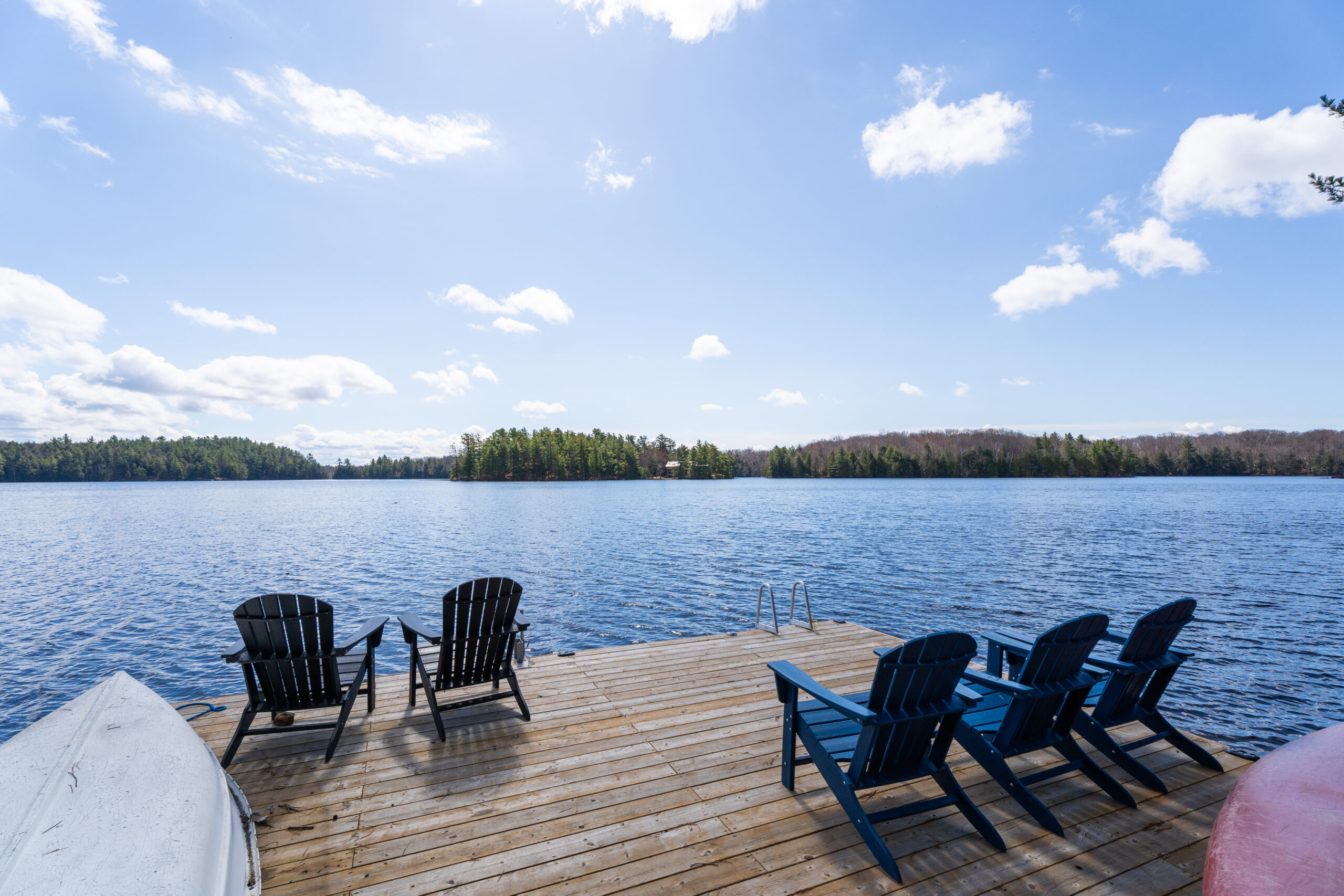 a photo of a dock with four muskoka chairs