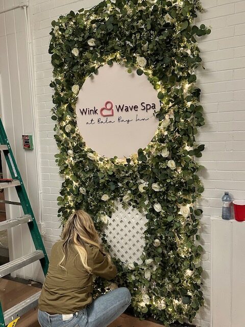 a sign with greenery around it