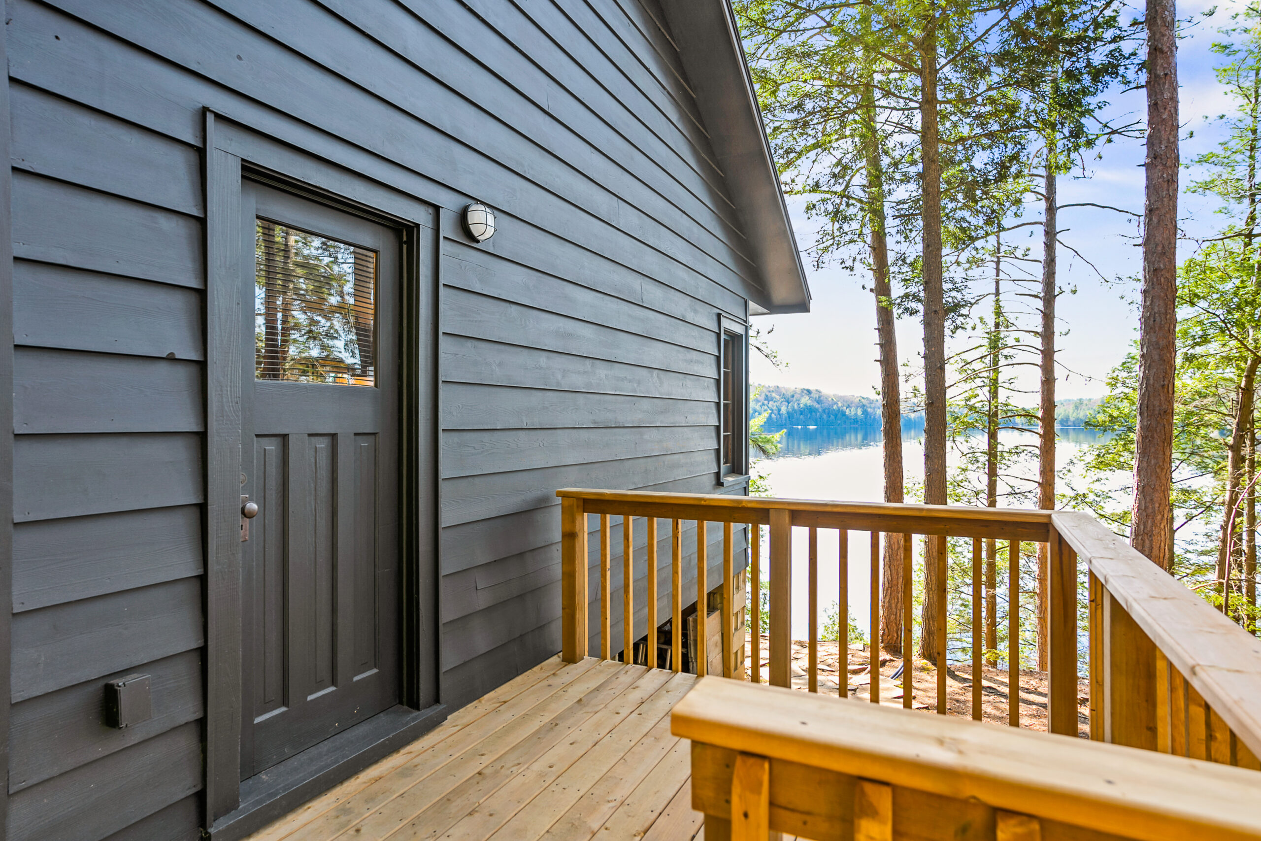 A dark grey panelled cottage with a dark grey door