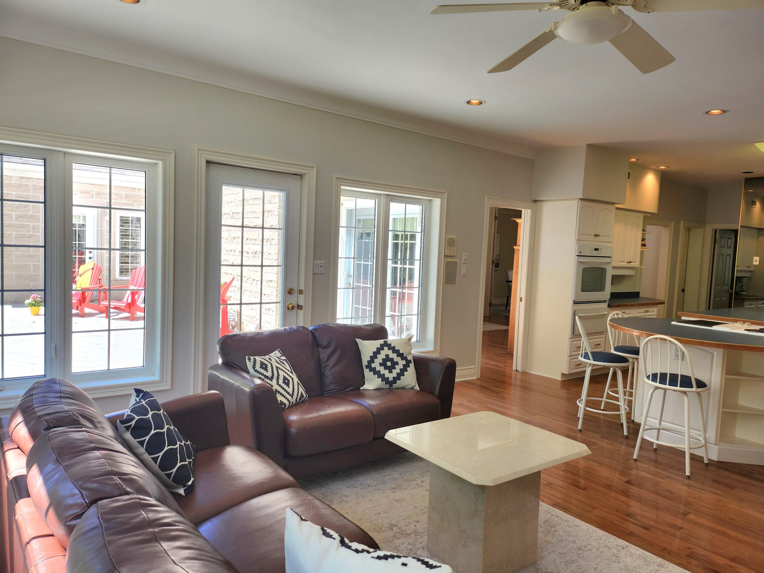 Brown leather loveseats face a small coffee table