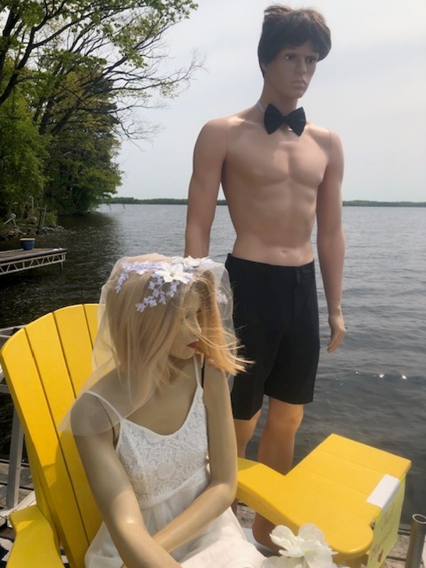 Two mannequins posing on a dock