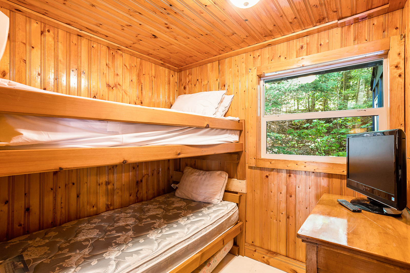 Built-in bunk beds attached to the left wall next to a small window