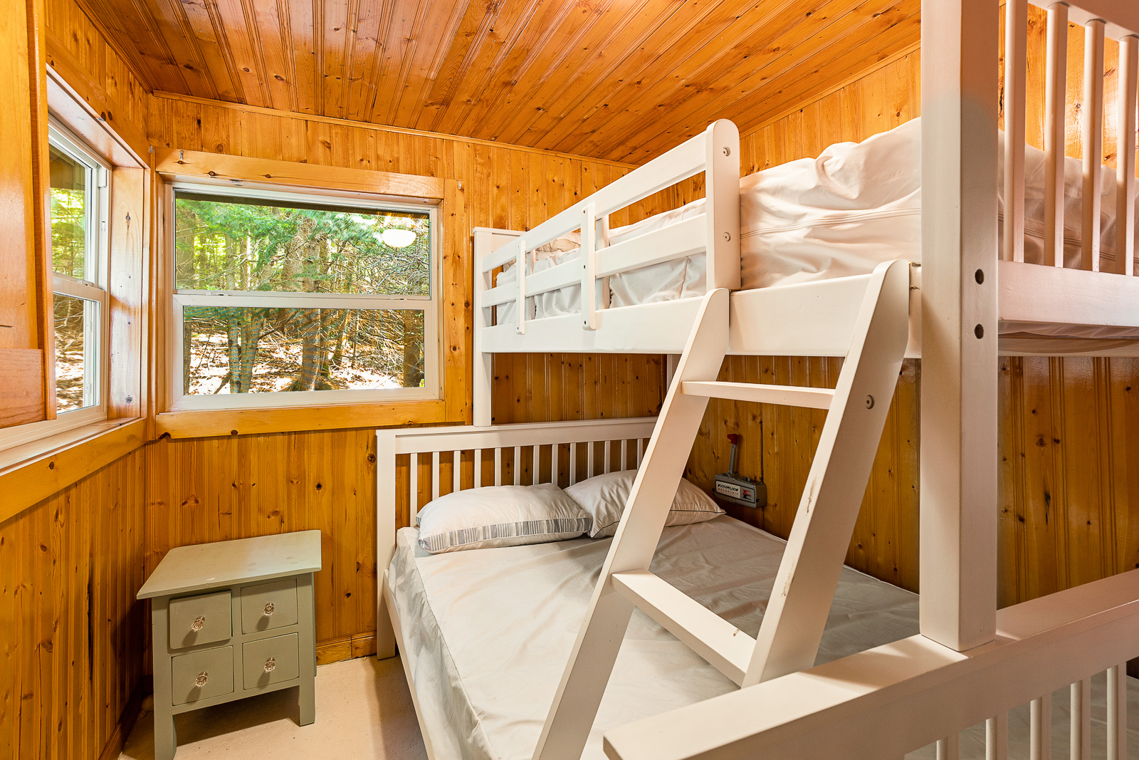 White bunk beds with a small white table to the left