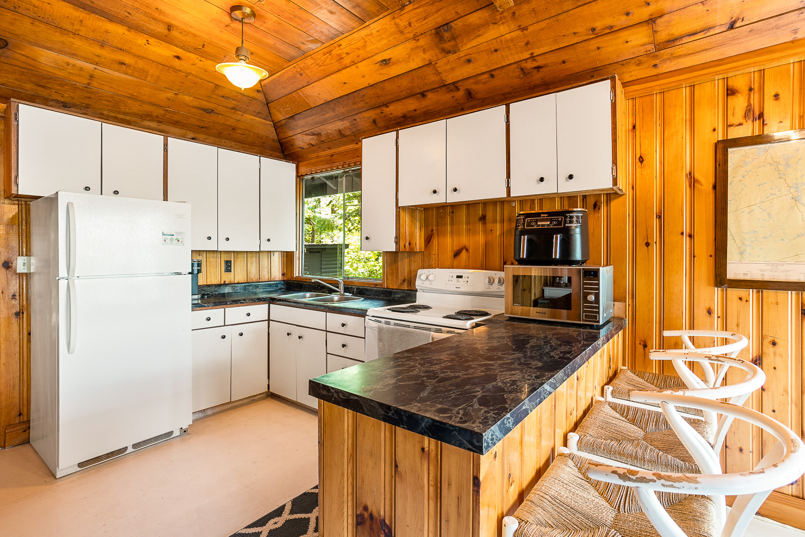 A white cabinet lined kitchen with a black-toped kitchen island