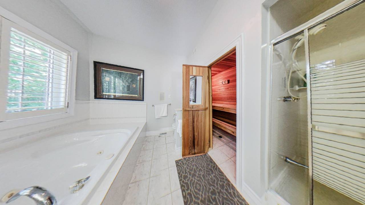 A large white bath faces an open sauna