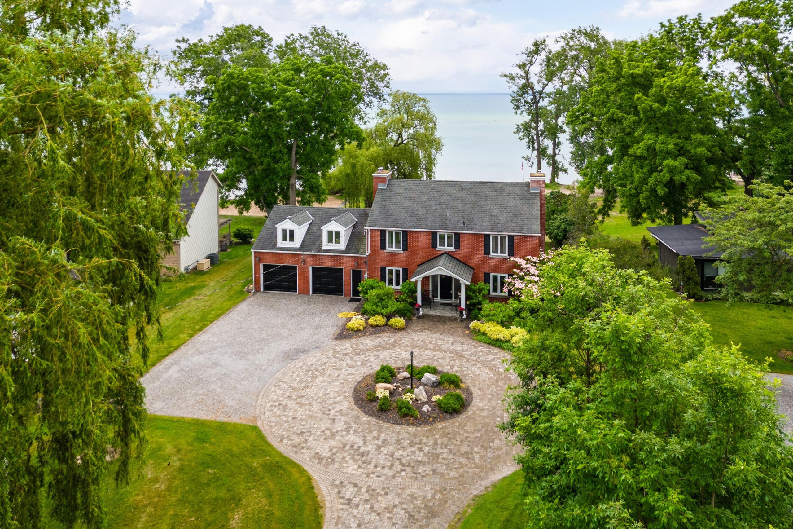 aerial view of a red brick house with a large, round driveway