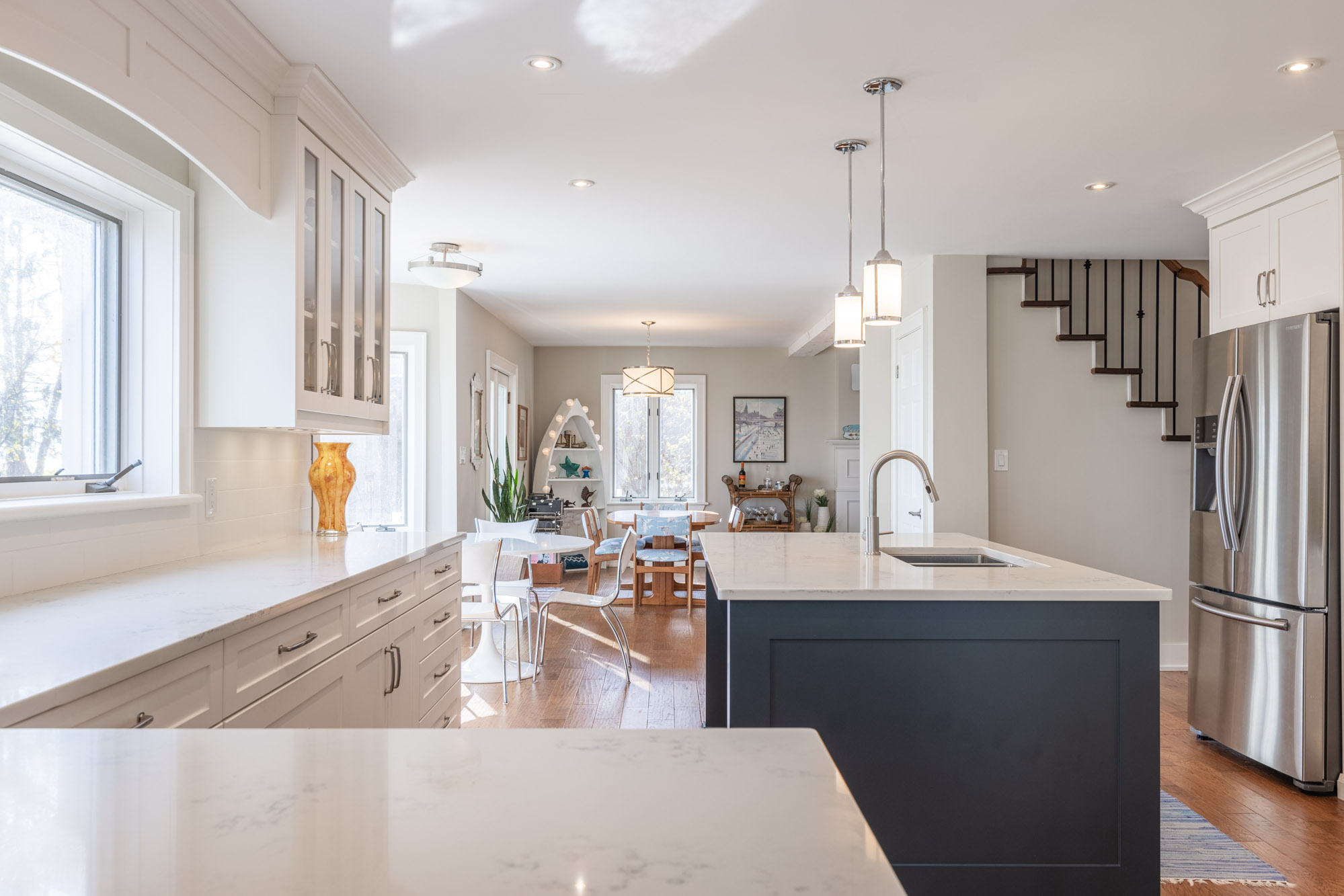 White countertops in the kitchen face a large blue kitchen island